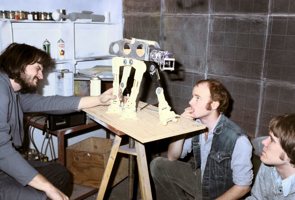 Stop-motion engineers study the movement of an AT-AT model's skeleton, behind the scenes of The Empire Strikes Back.