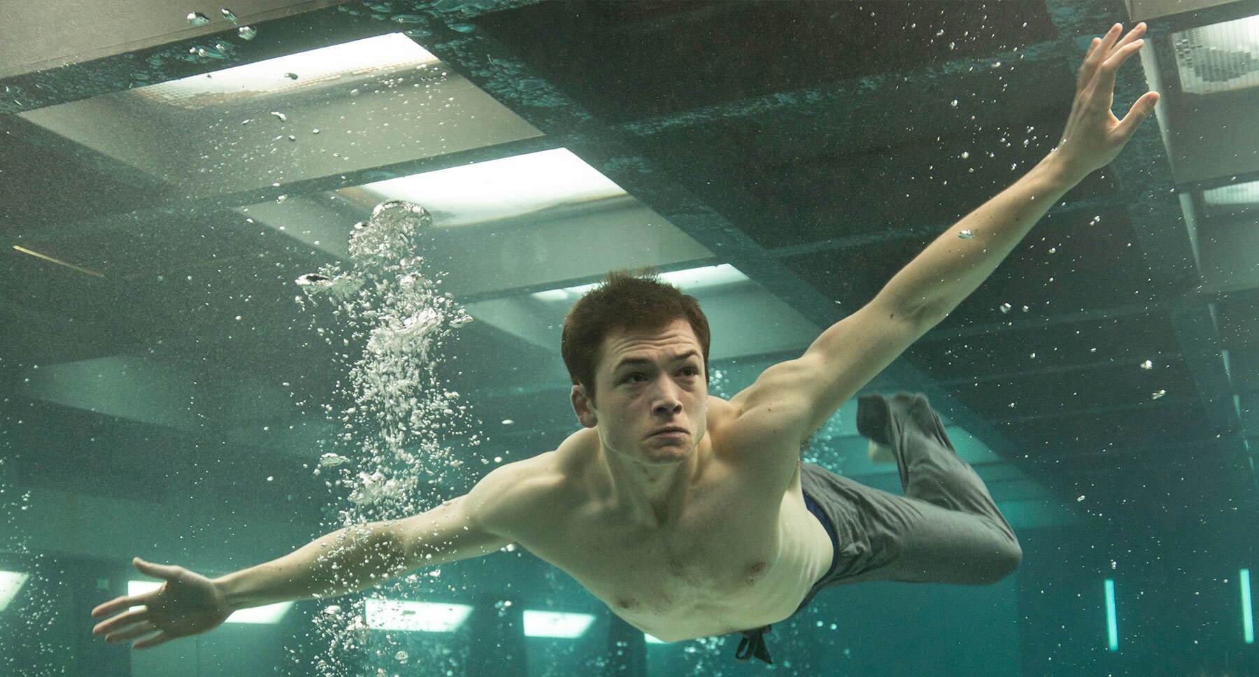 Taron Egerton (as Gary 'Eggsy' Unwin) swimming in a flooded room in "Kingsman: The Secret Service"