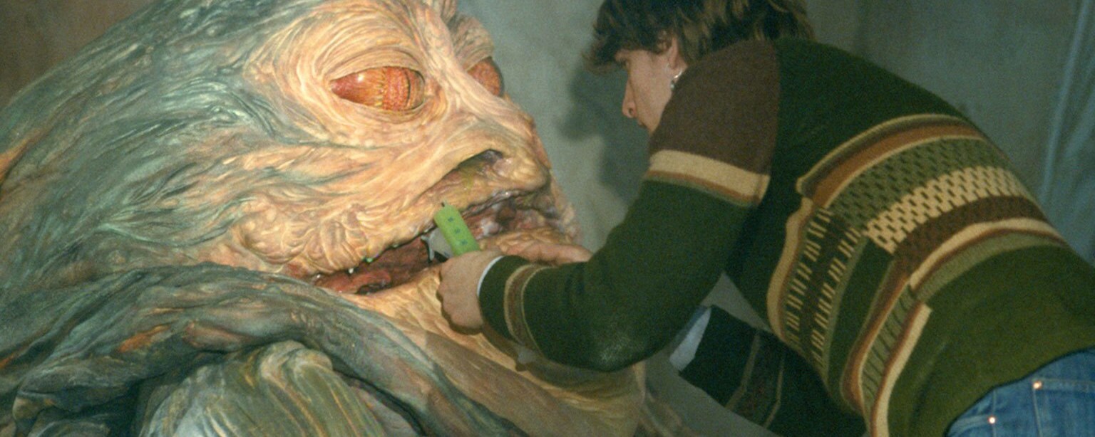 A Jabba the Hutt designer adds elements to the creature's clay and foam body with a syringe.