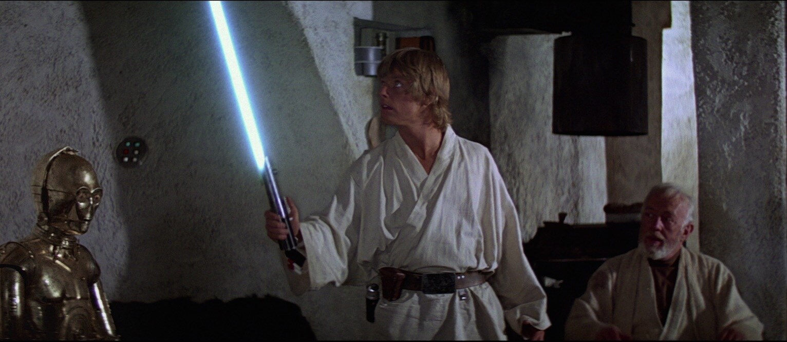 Luke Skywalker igniting his father's lightsaber for the first time