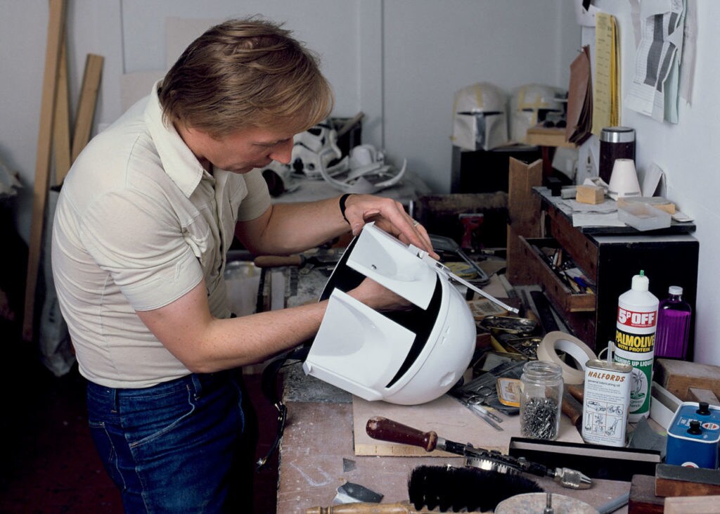 A craftsman works on Boba Fett's helmet.
