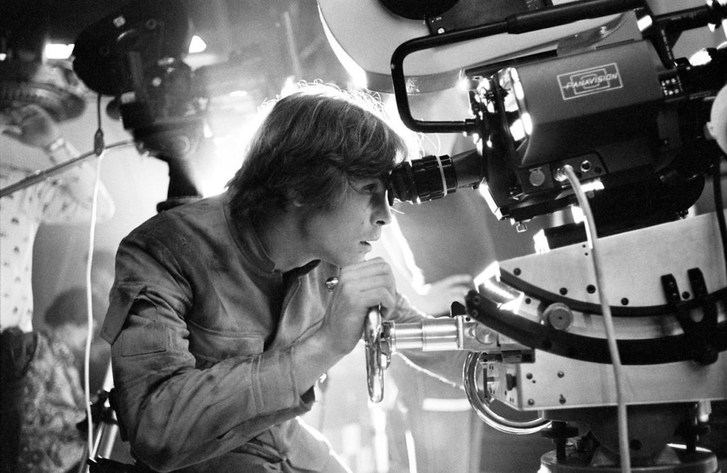 Mark Hamill peers through a camera viewfinder on the set of Star Wars: The Empire Strikes Back.