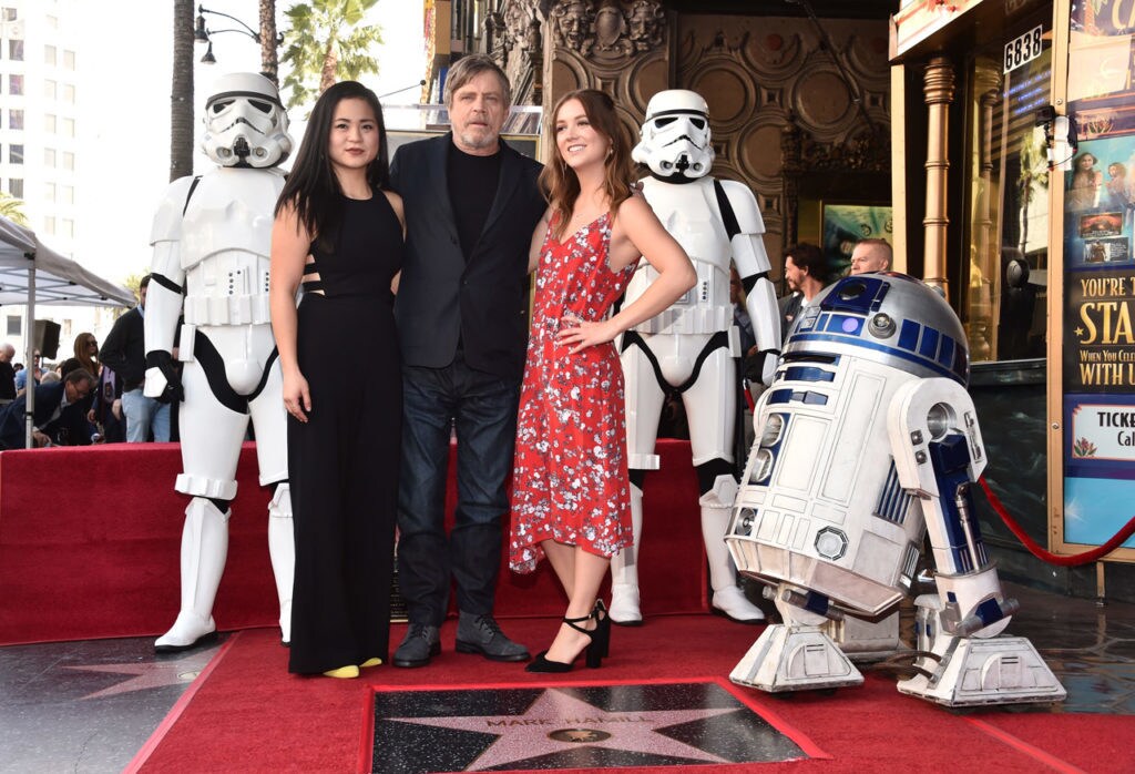 Mark Hamill poses for a photo with Kelly Marie Tran, Billie Lourd, R2-D2, and two stormtroopers at an event honoring him with a star on the Hollywood Walk of Fame.