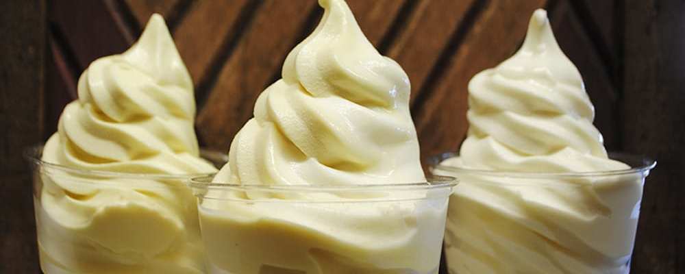 Three soft serve vanilla ice creams.