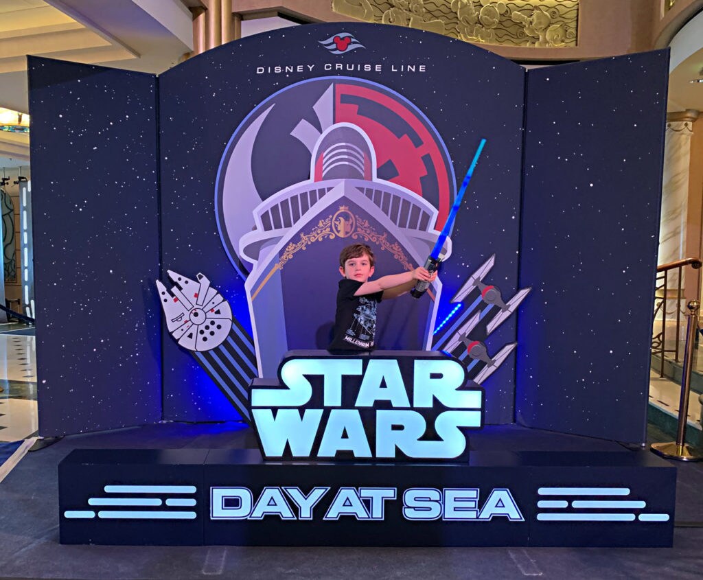 A young fan with his lightsaber on Star Wars Day at Sea.