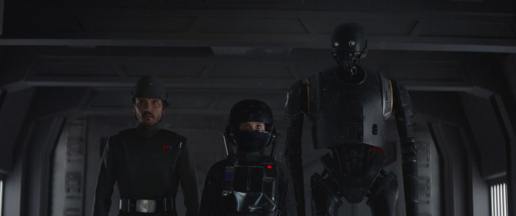 Cassian Andor, Jyn Erso, and K-2SO infiltrate an Imperial base in Rogue One.