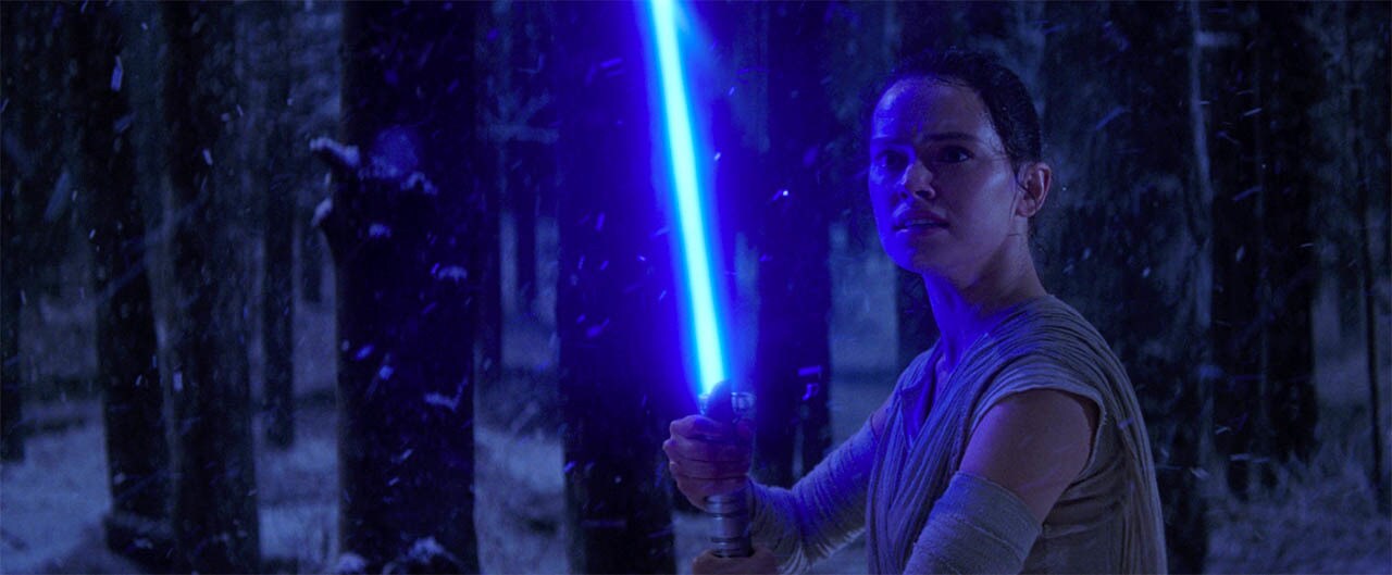 Rey takes a lightsaber from Kylo Ren.