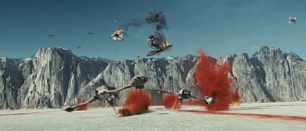 A TIE fighter explodes above two ski speeders at the Battle of Crait.