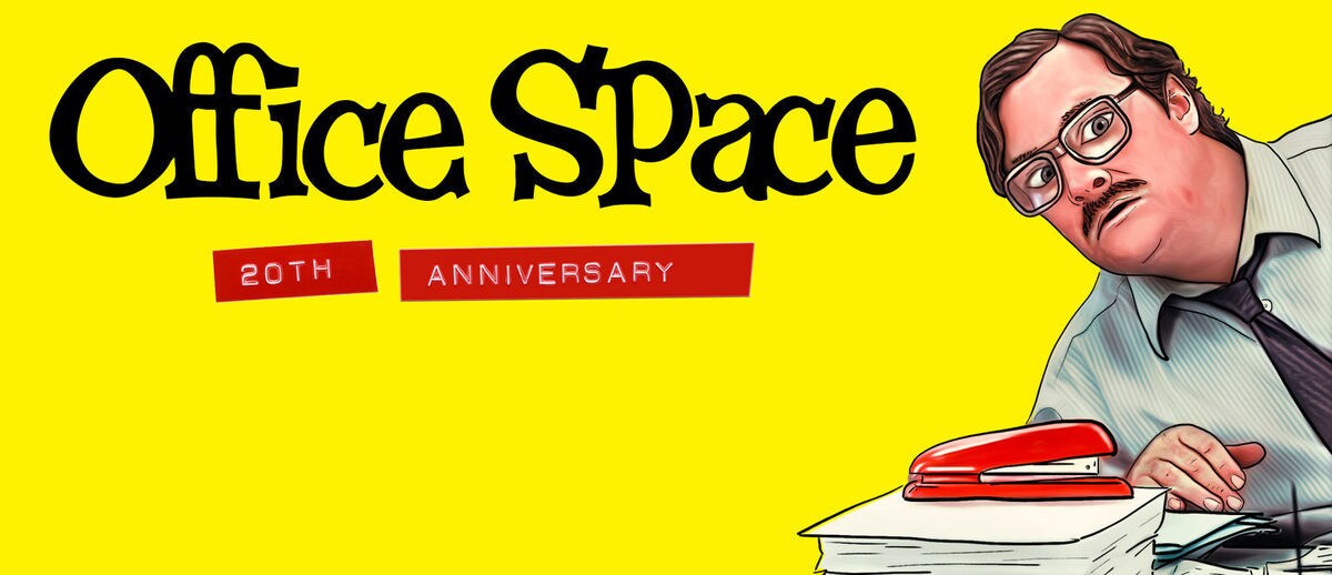 Milton (actor Stephen Root) peering over a stack of paper with his red stapler on top from the movie "Office Space".