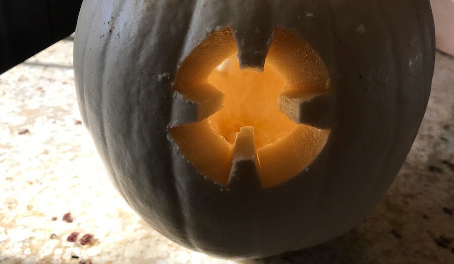 A 4-pronged BB-8 template carved into a black pumpkin.