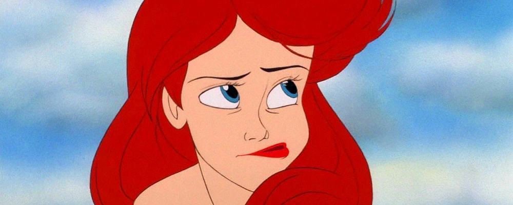 Ariel from The Little Mermaid blows hair out of her face.