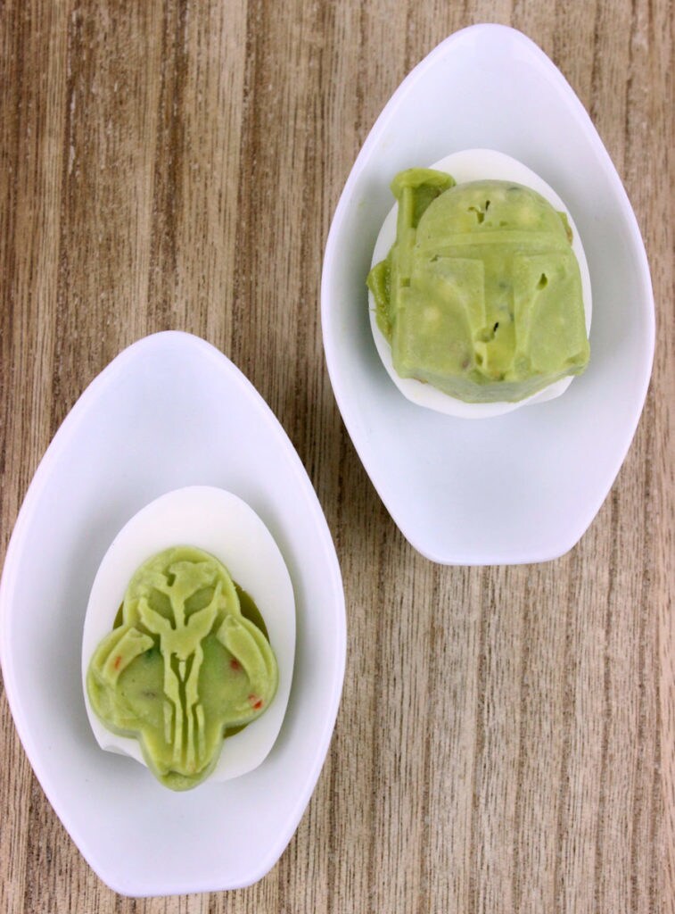 Boba Fett Guacamole Deviled Eggs, which showcase Boba Fett with his Mandalorian armor made out of a guacamole filling, sit in two bowls.