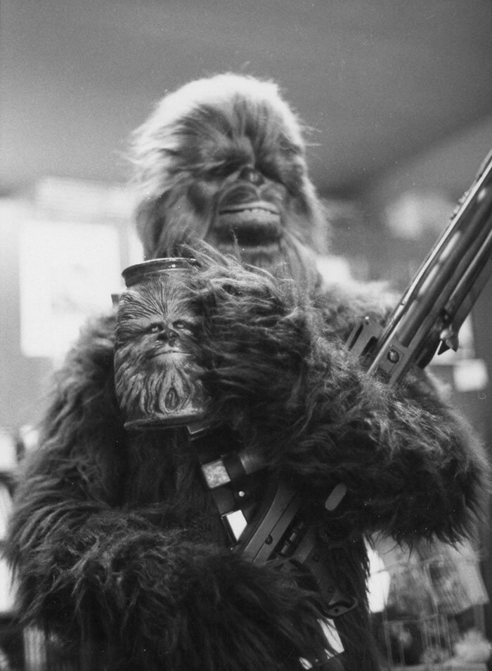 An early Chewbacca cosplayer holds a Chewbacca mug, in a black and white photo.