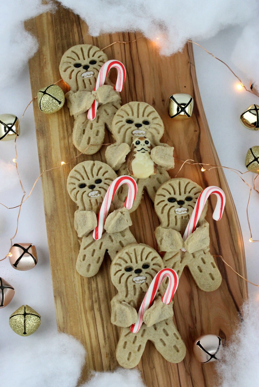Holiday Hug Wookiee Cookies. Five cookies, in the shape of Wookiees, lie on a wooden board hugging candy canes.