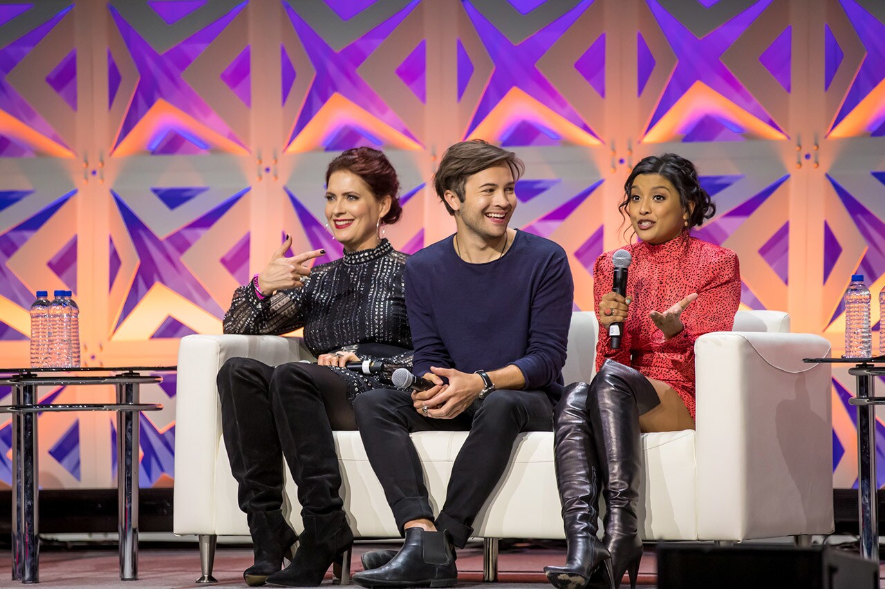 Star Wars Rebels actors Vanessa Marshall, Taylor Gray, and Tiya Sircar sit together on a couch while speaking on stage at Star Wars Celebration Chicago.