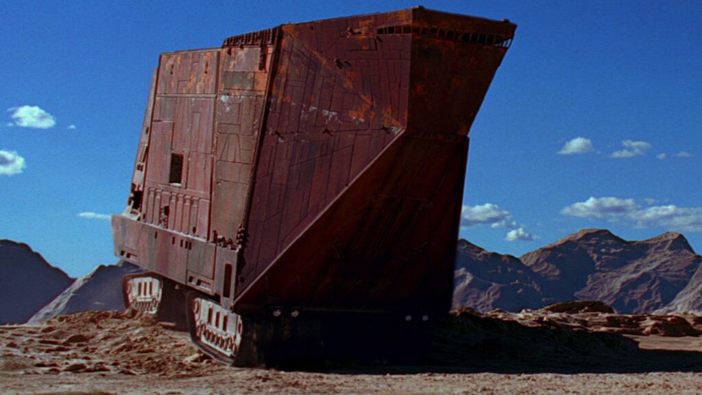 A Sandcrawler rolling fortress drives across the desert of Tatooine.