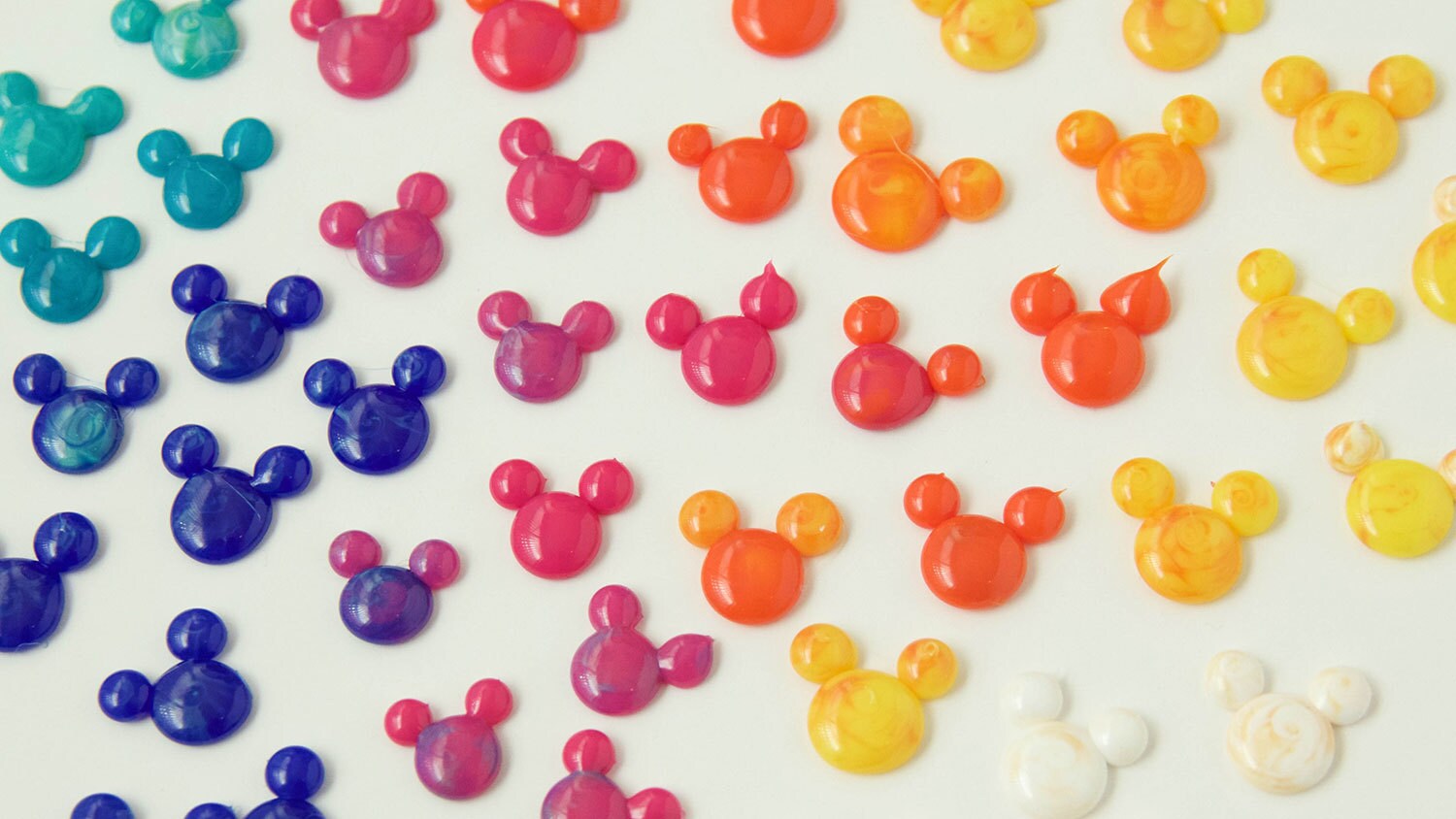 Colorful Mickey Mouse heads made of three dots of hot glue, a large one for the head and two smaller ones for the ears.