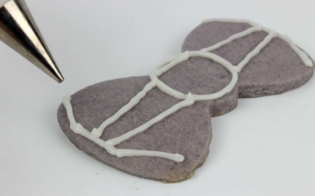 A bowtie cookie is frosted to look like a TIE fighter.
