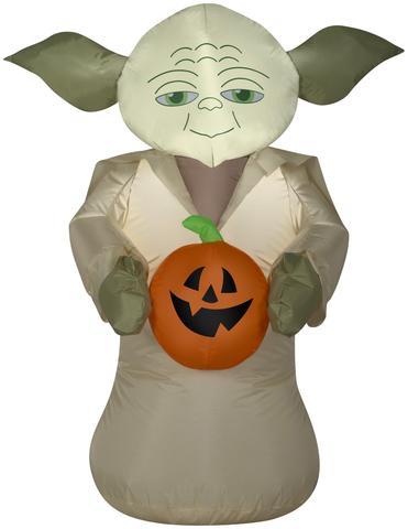 A Halloween inflatable Yoda holding a pumpkin.