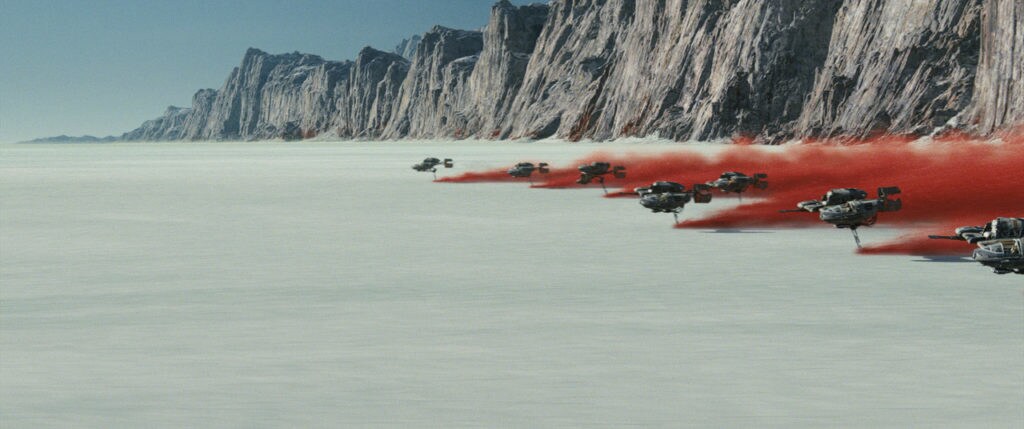 Ski speeders trail red plumes of dust above a salt field in the Battle of Crait.