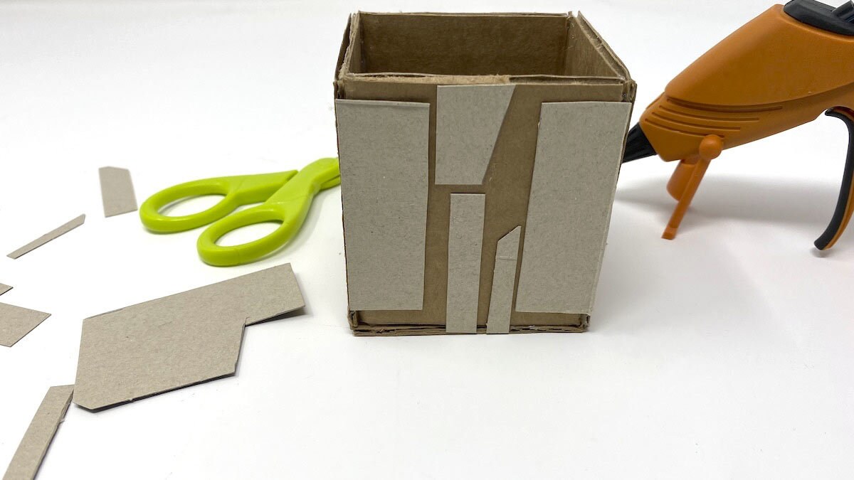 Cut several small polygonal shapes from the food packaging cardboard