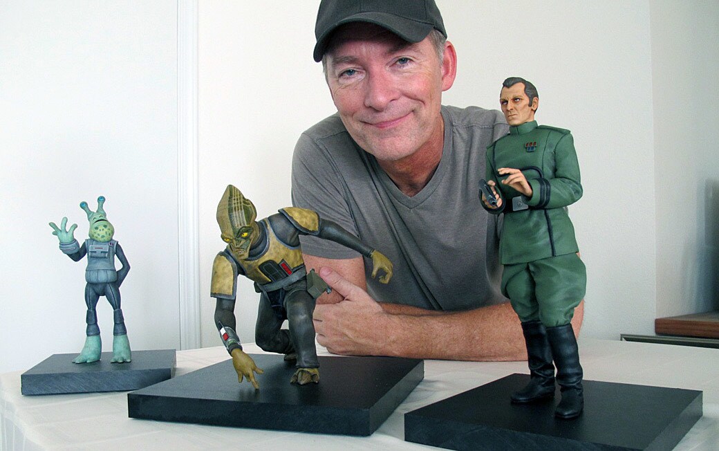 Voice actor Stephen Stanton stands behind figurines of characters he's played in the Star Wars saga.