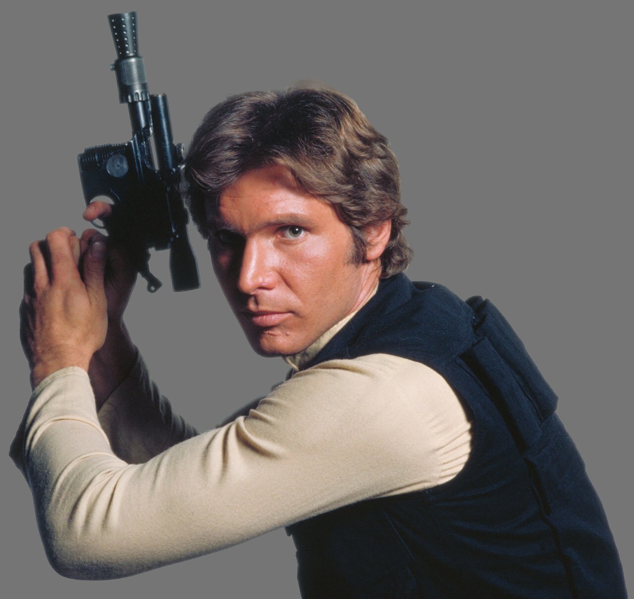 Harrison Ford as Han Solo holds a blaster pistol with both hands in a publicity photo for A New Hope.