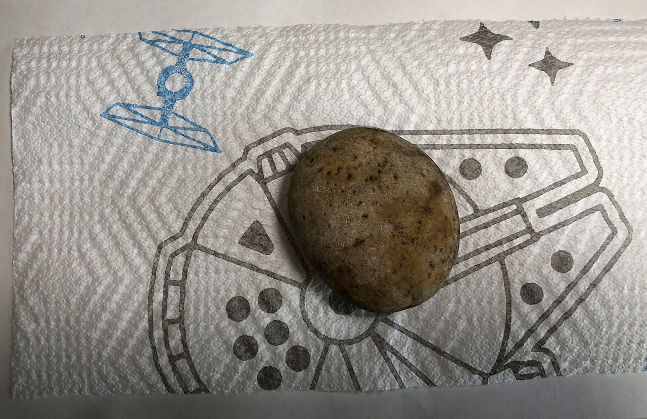 A large stone sits on a Star Wars decorated paper towel.