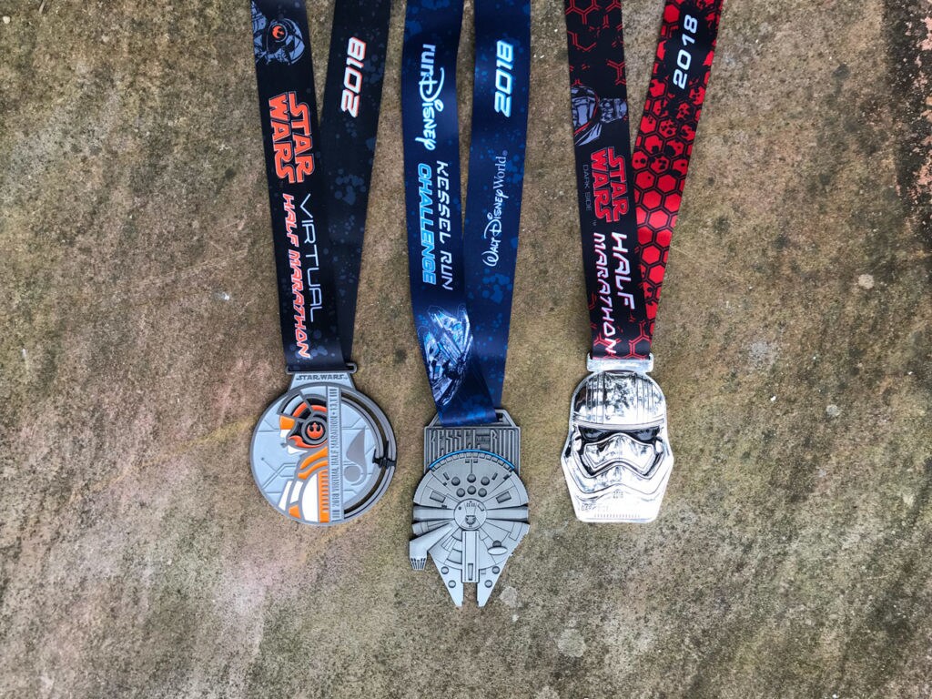 Three different challenge medals for the 2018 Star Wars virtual half marathon feature BB-8, the Millennium Falcon, and a Stormtrooper.