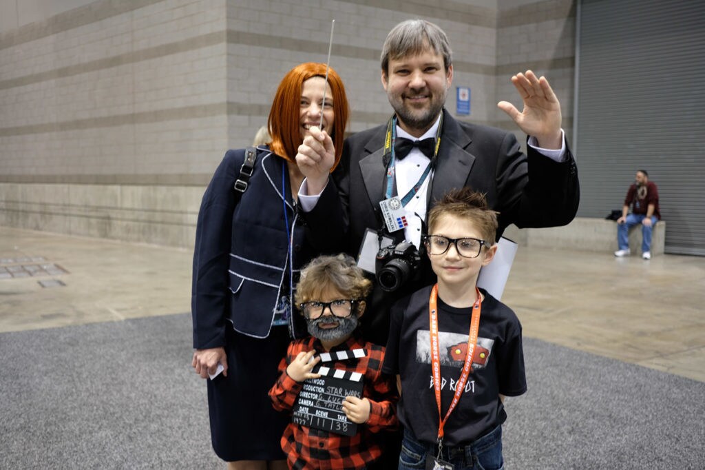 Family of cosplayers dressed as Kathleen Kennedy, George Lucas, J.J. Abrams, and John Williams.