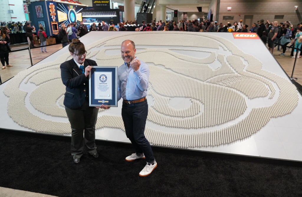 Michael McNally, LEGO Group senior director of brand relations, right, accepts a certificate of achievement from Guinness World Records.