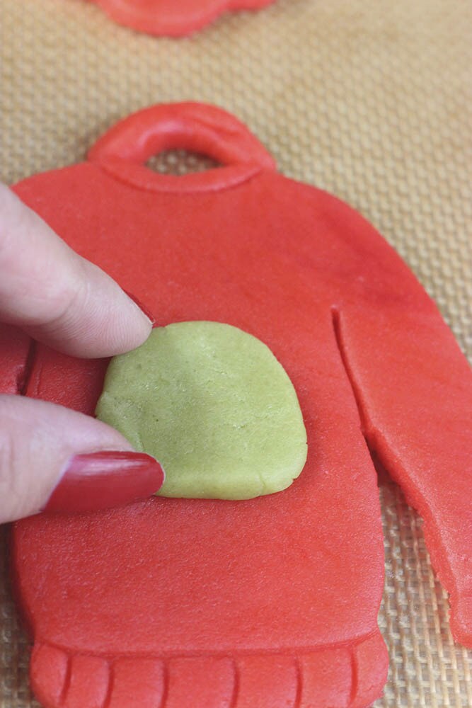 Step 11 - Roll out the green dough to about 1/4 inch thick and cut out a small piece in the shape of Boba Fett’s helmet