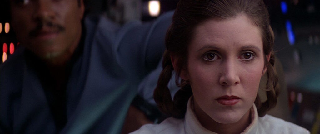 Princess Leia receives a telepathic message from Luke, with Lando Calrissian behind her on the Millennium Falcon, in Star Wars: The Empire Strikes Back.