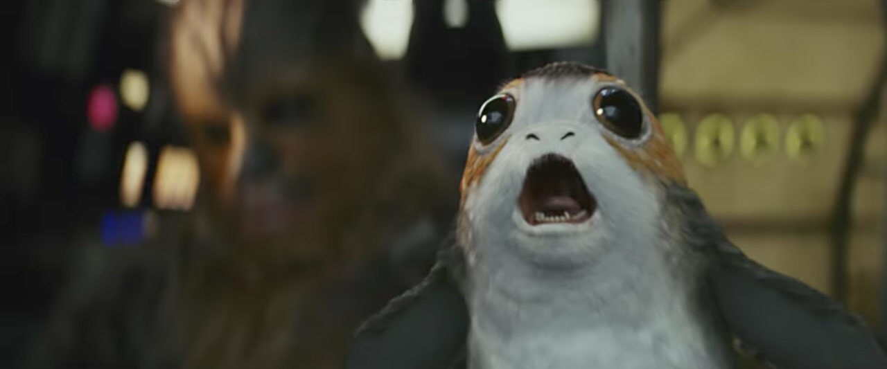 A porg yells on the cockpit of the Millennium Falcon.