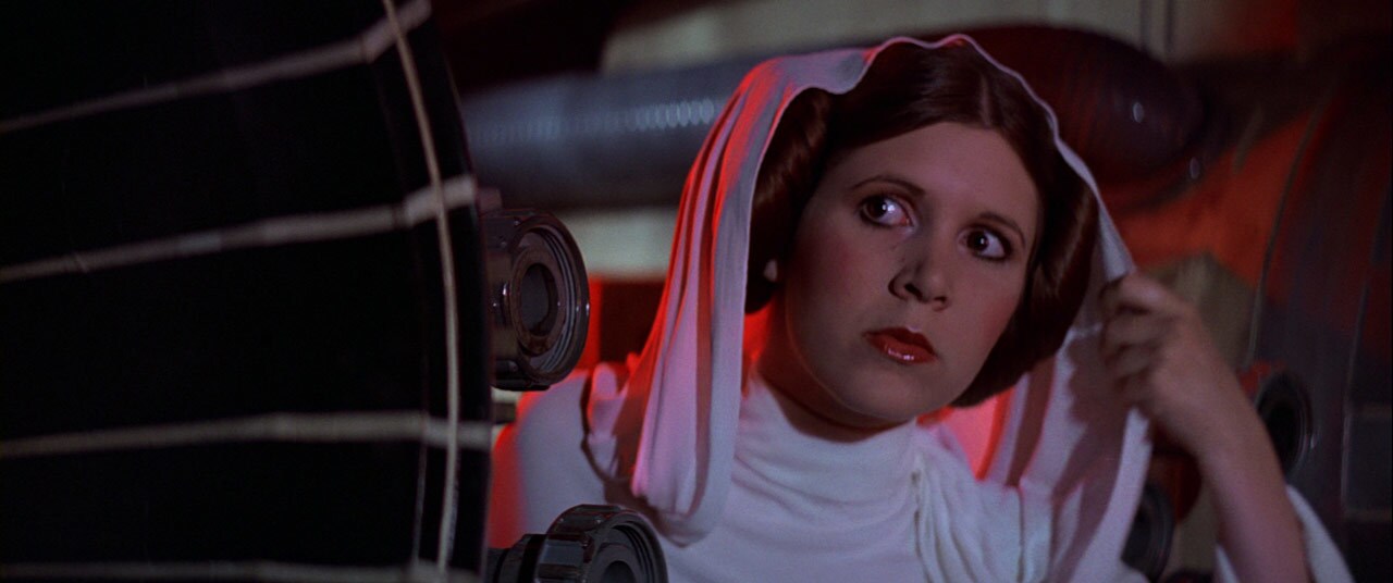 Princess Leia with her hair in double buns and a white hood in Star Wars: A New Hope.