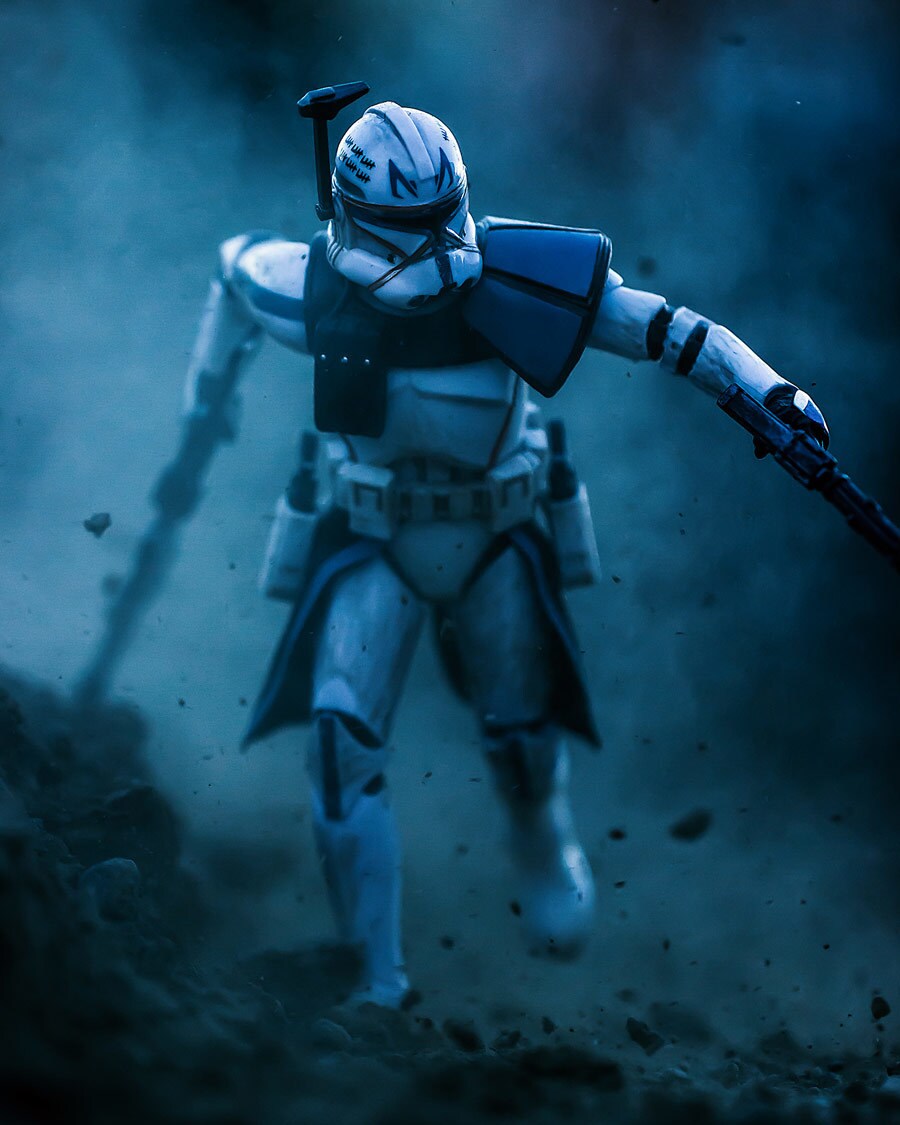 A Captain Rex action figure, posed holding blasters and running in battle.