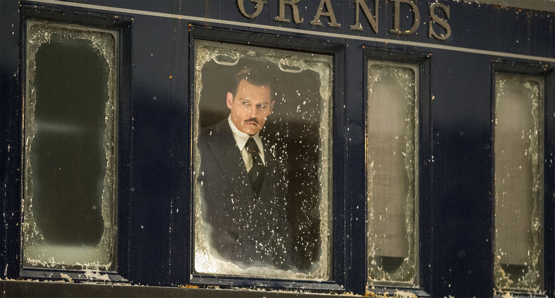 Johnny Depp (as Edward Ratchett) looking out a snow covered train window in "Murder on the Orient Express"