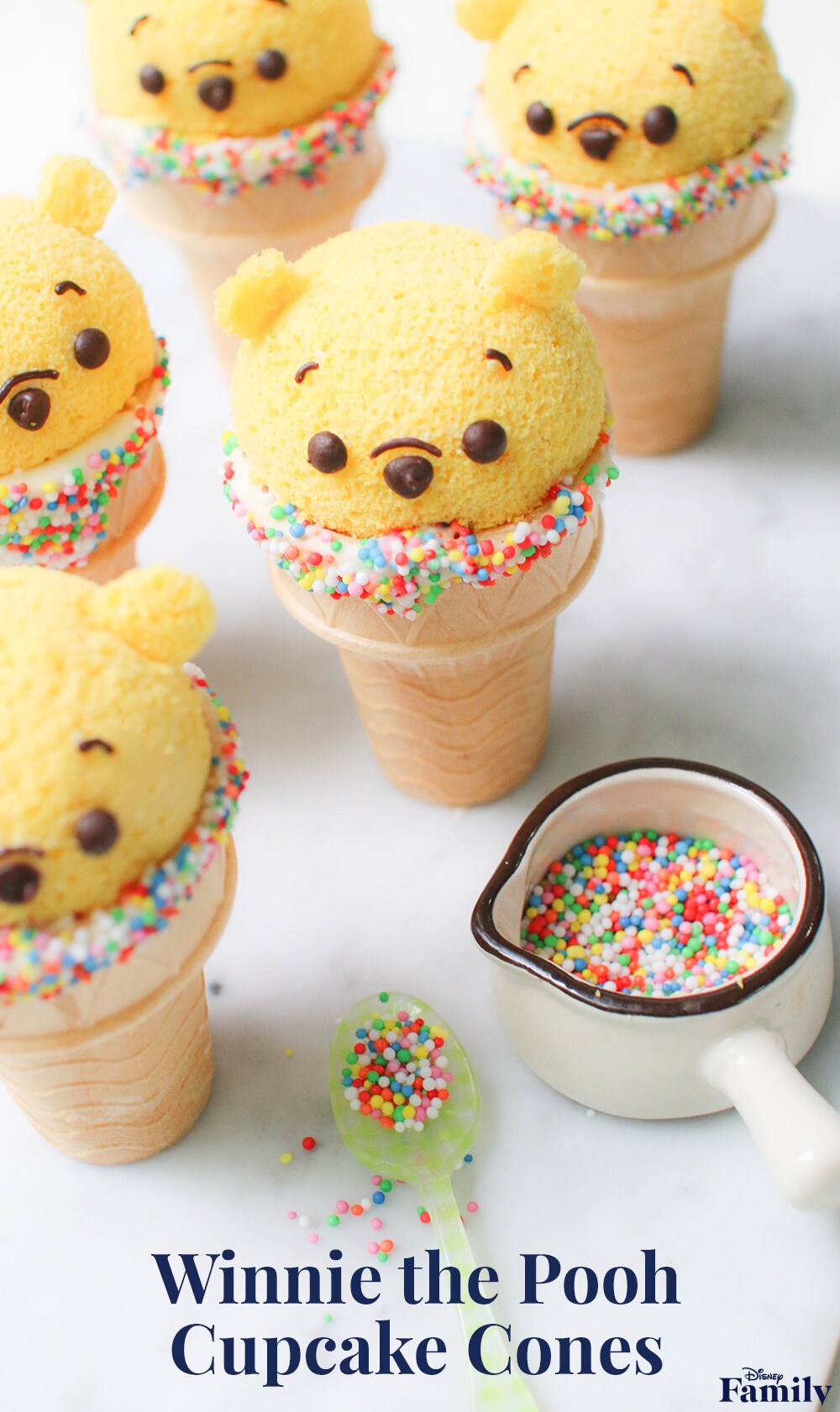 Several Winnie the Pooh shaped cupcakes in sprinkle covered ice cream cones.