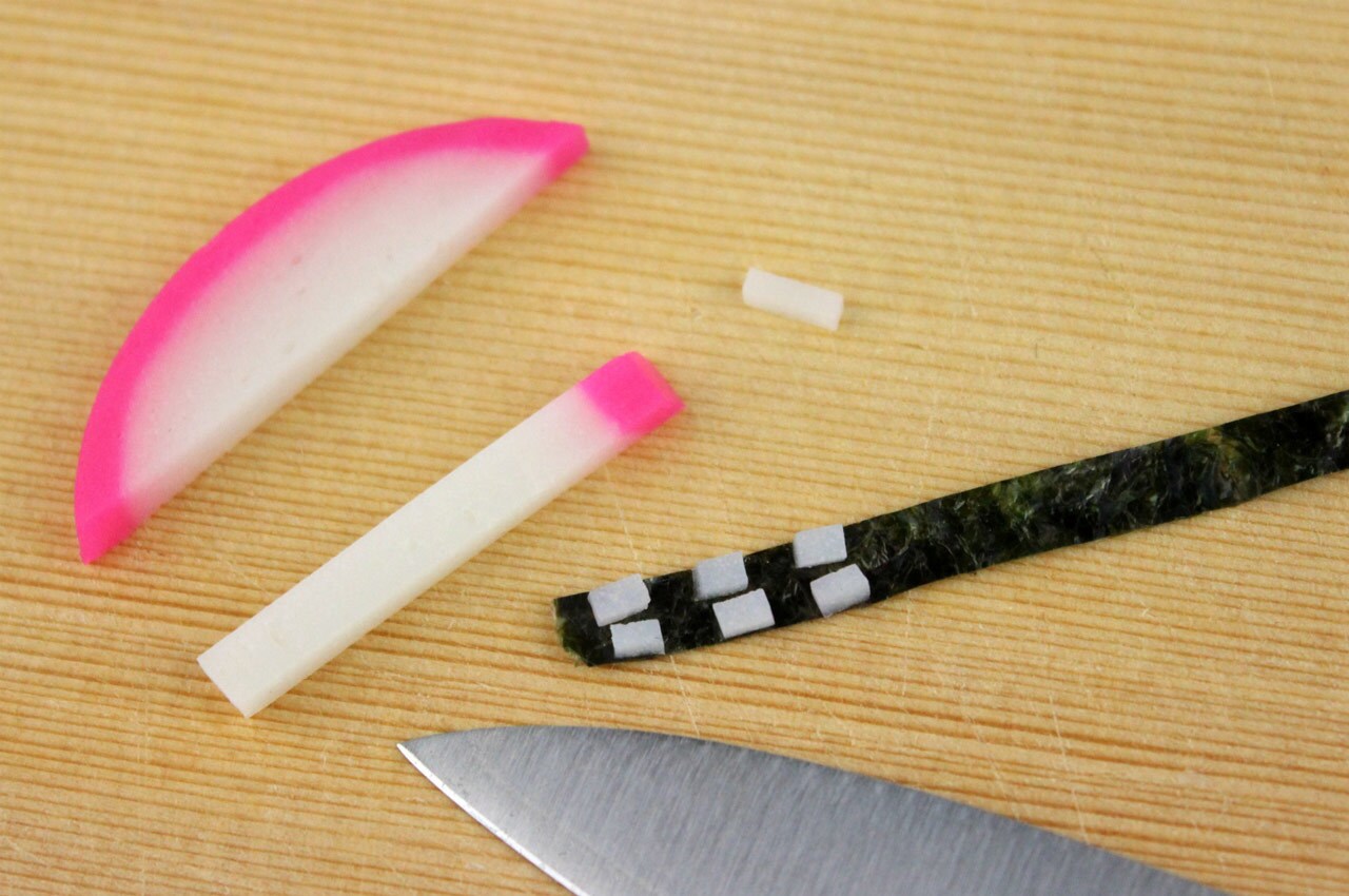 Cutting seaweed into strips and kamaboko into squares for Chewbacca noodle rolls.