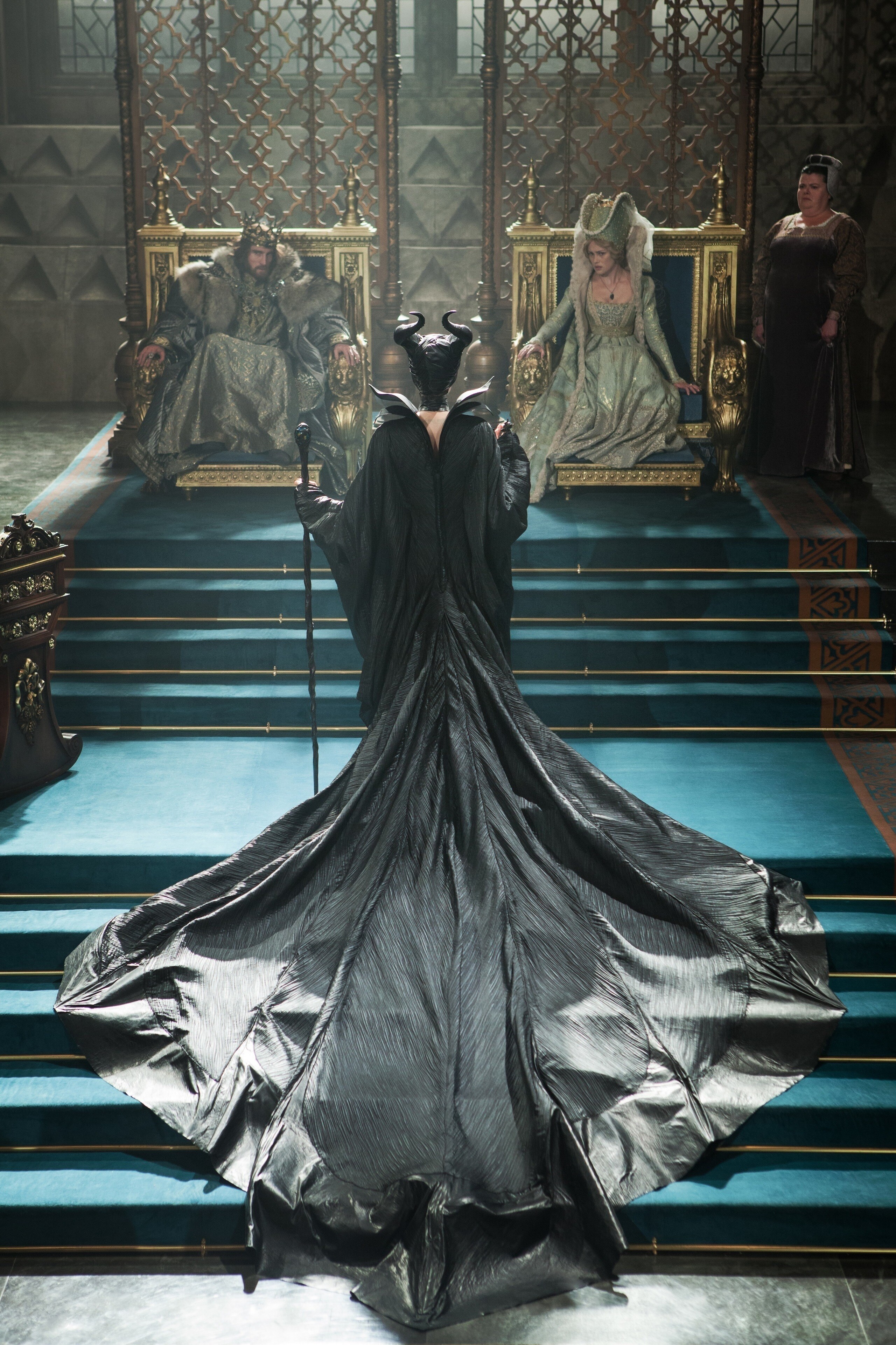 Angelina Jolie as Maleficent standing before Sharlto Copley as Stefan, Hannah New as Princess Leila, and Sarah Flind as Princess Leila's Handmaiden in "Maleficent"