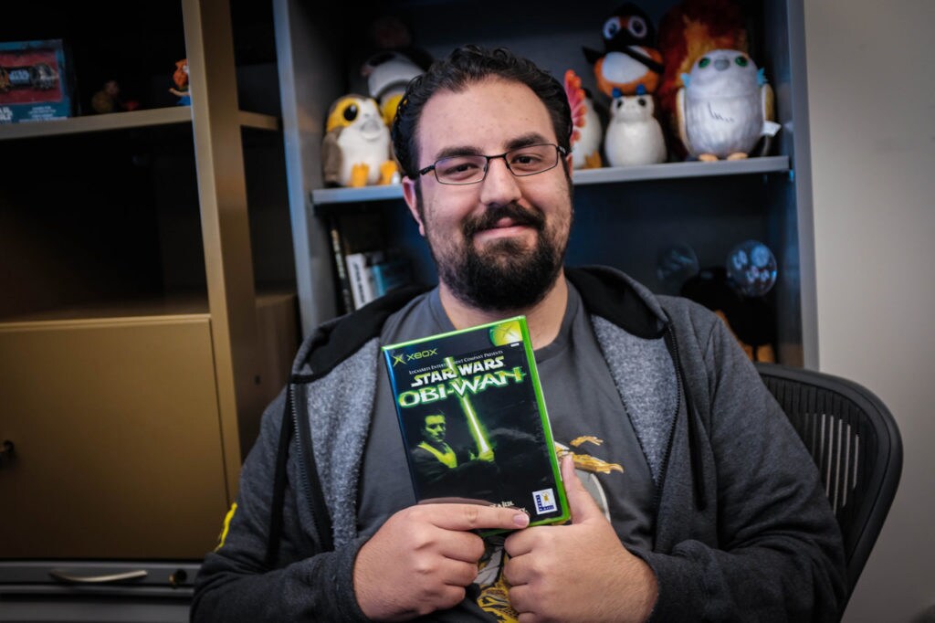 A member of the Lucasfilm Games Team holds up the box of Star Wars: Obi-Wan.