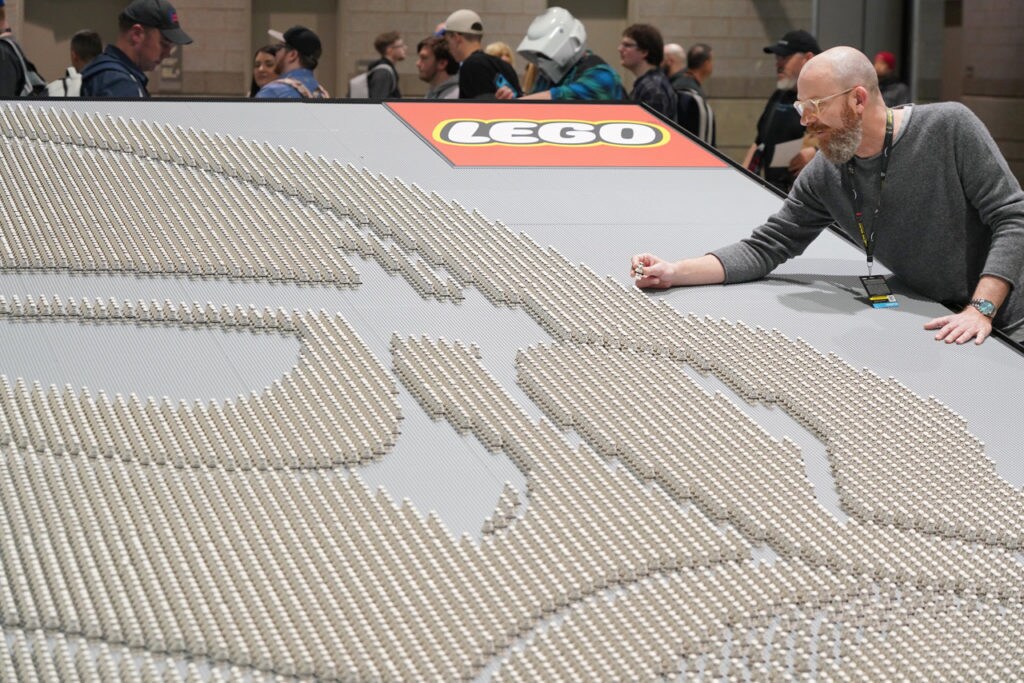 LEGO Star Wars Design Director Jens Kronvold Frederiksen places a final piece on the largest display of LEGO Star Wars minifigures ever at Star Wars Celebration Chicago.