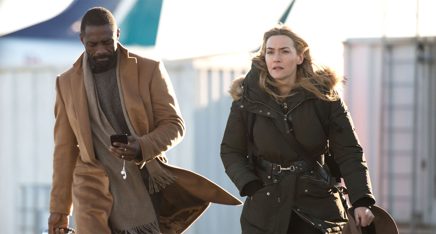 Idris Elba (as Ben Bass) and Kate Winslet (as Alex Martin) walking in the movie "The Mountain Between Us"