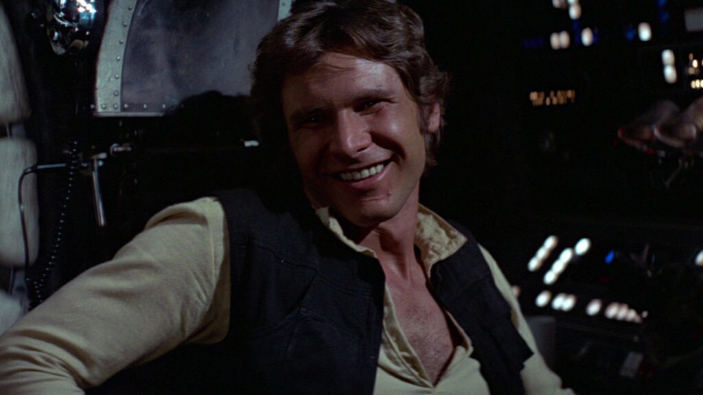 Han smiles and leans back in the Millennium Falcon cockpit.