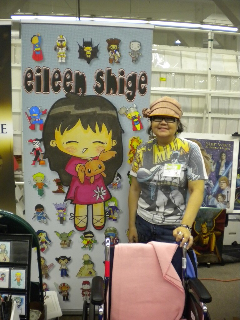 Eileen Shige, a Star Wars fan and cancer victim, smiles while standing next to a board with her name on it at a convention.