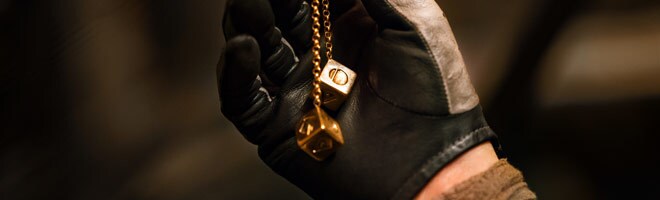 A gloved hand holds a set of chance cubes in Solo: A Star Wars Story.