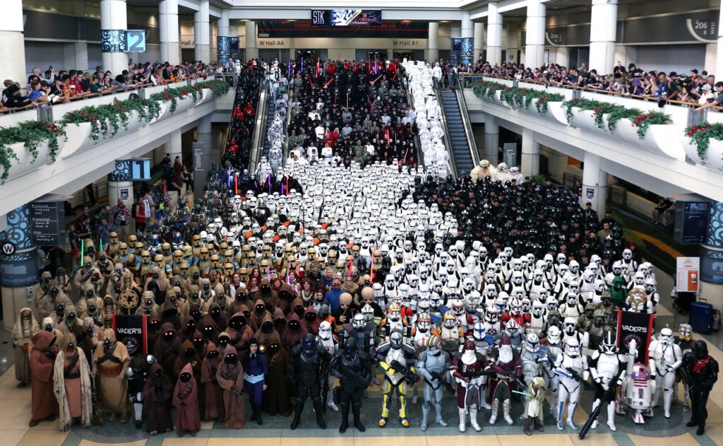 A crowd of Star Wars cosplayers in a variety of costumes, including stormtroopers and Jawas.