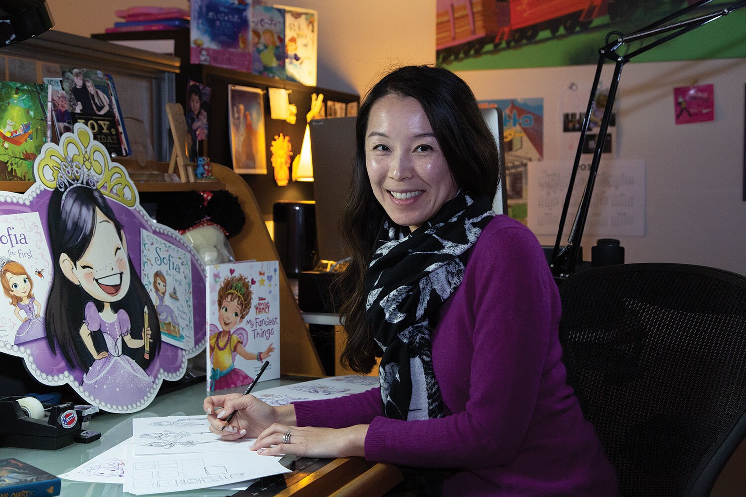 Grace Lee, a Disney storybook artist, sits at her desk.
