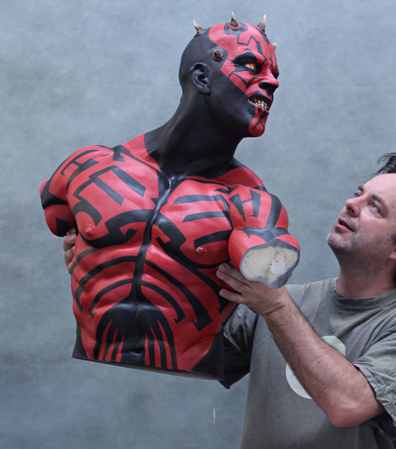 A life-sized bust of Darth Maul held up by a man.
