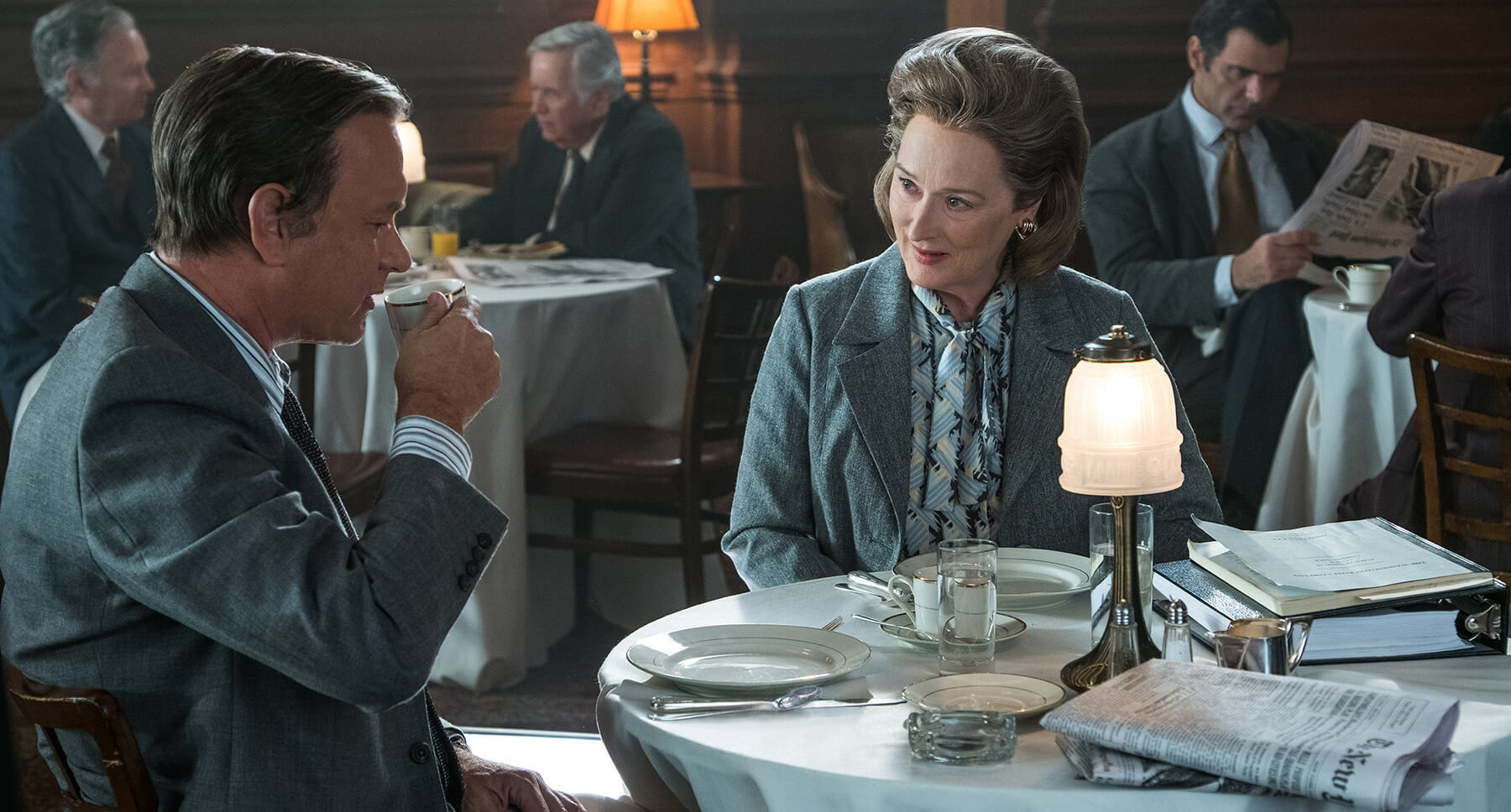 Tom Hanks and Meryl Streep sitting at a table in "The Post"